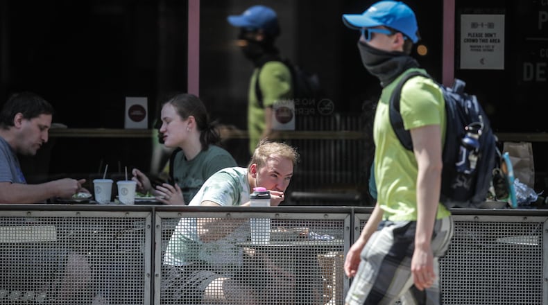Brown Street was busy on a warm Tuesday afternoon. The Centers for Disease Control and Prevention eased its guidelines Tuesday, April 27, 2021, on the wearing of masks outdoors, saying fully vaccinated Americans don’t need to cover their faces anymore unless they are in a big crowd of strangers. JIM NOELKER/STAFF
