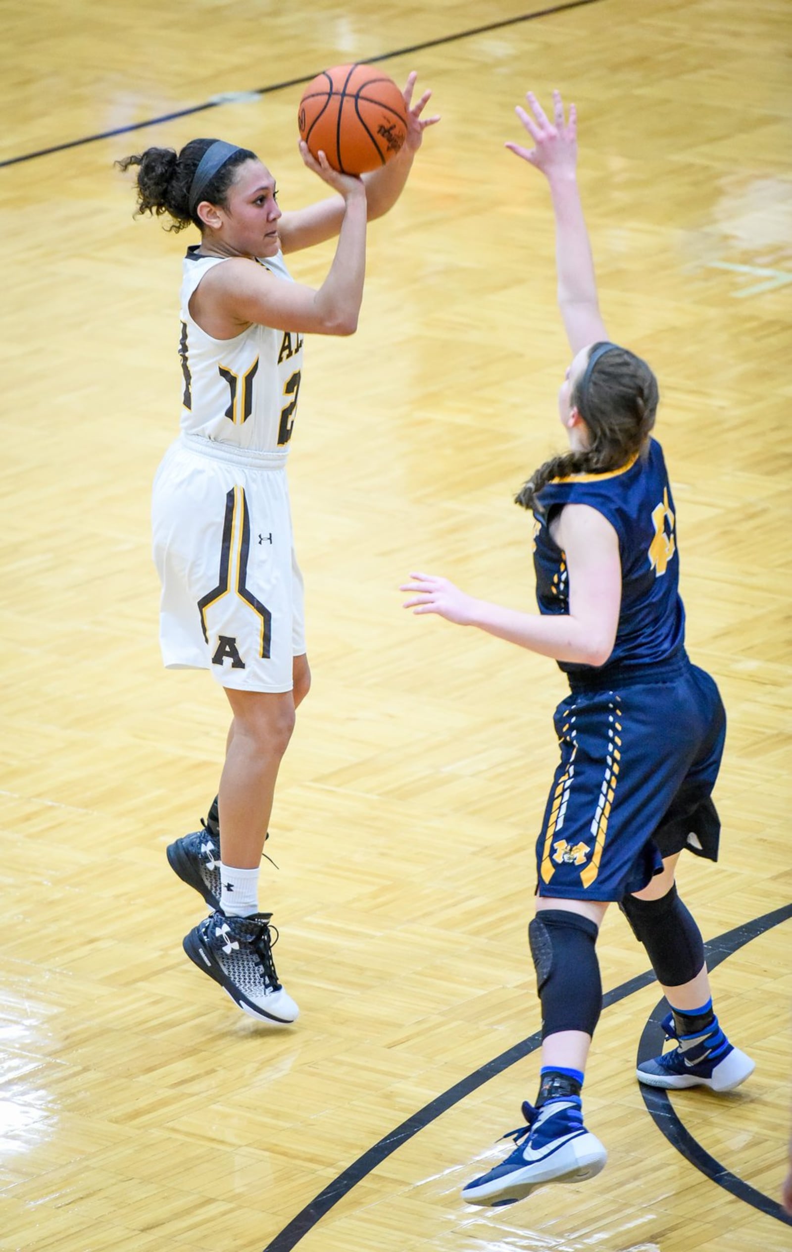Alter’s Braxtin Miller launches a shot over Monroe’s Katie Sloneker during Thursday night’s Division II sectional final at Lebanon. NICK GRAHAM/STAFF