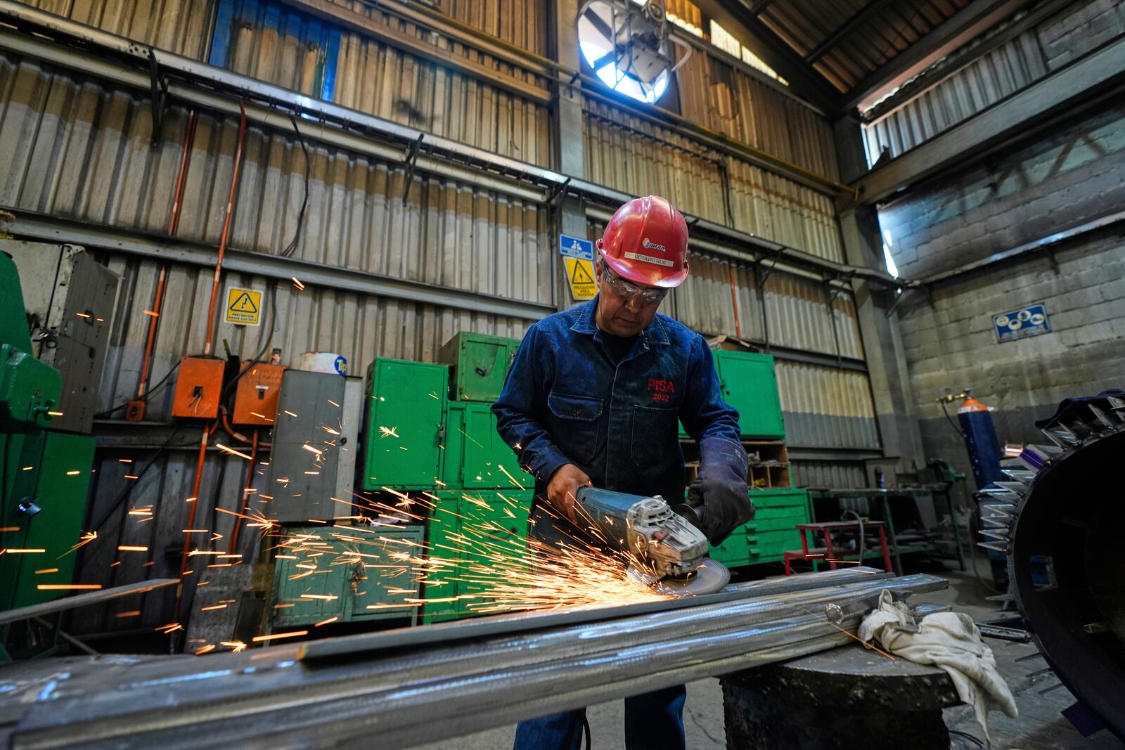 A worker sands metal at an electric engine plant in Mexico City, Wednesday, April 2, 2025. (AP Photo/Fernando Llano)