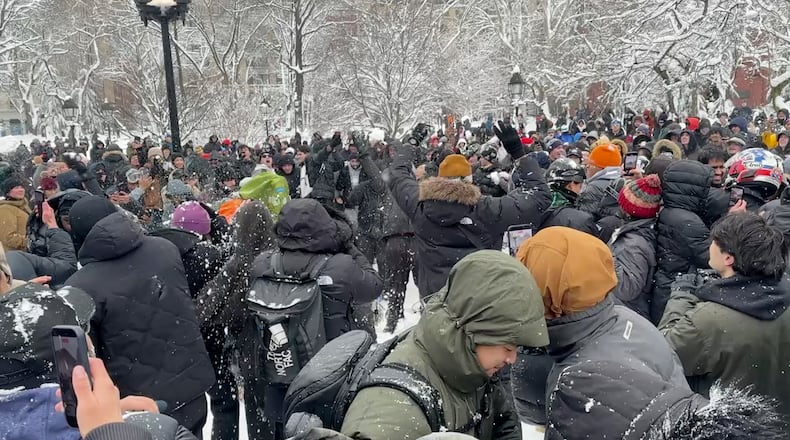 In this photo taken from video, people throw and duck snowballs during a snowball fight at Washington Square Park, Monday, February. 23, 2026 in New York. (AP Photo/David R. Martin)