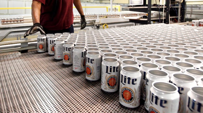 MillerCoors production technician, Lionrick Bolar, moves Miller Lite cans to be filled on the line at the MillerCoors Brewery in Trenton, Ohio. NICK DAGGY / STAFF