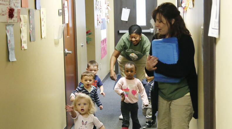 Good Shepherd Academy center toddlers sing a walking song as they walk the hallway at the Jubilee Community Church in Springboro. TY GREENLEES / STAFF