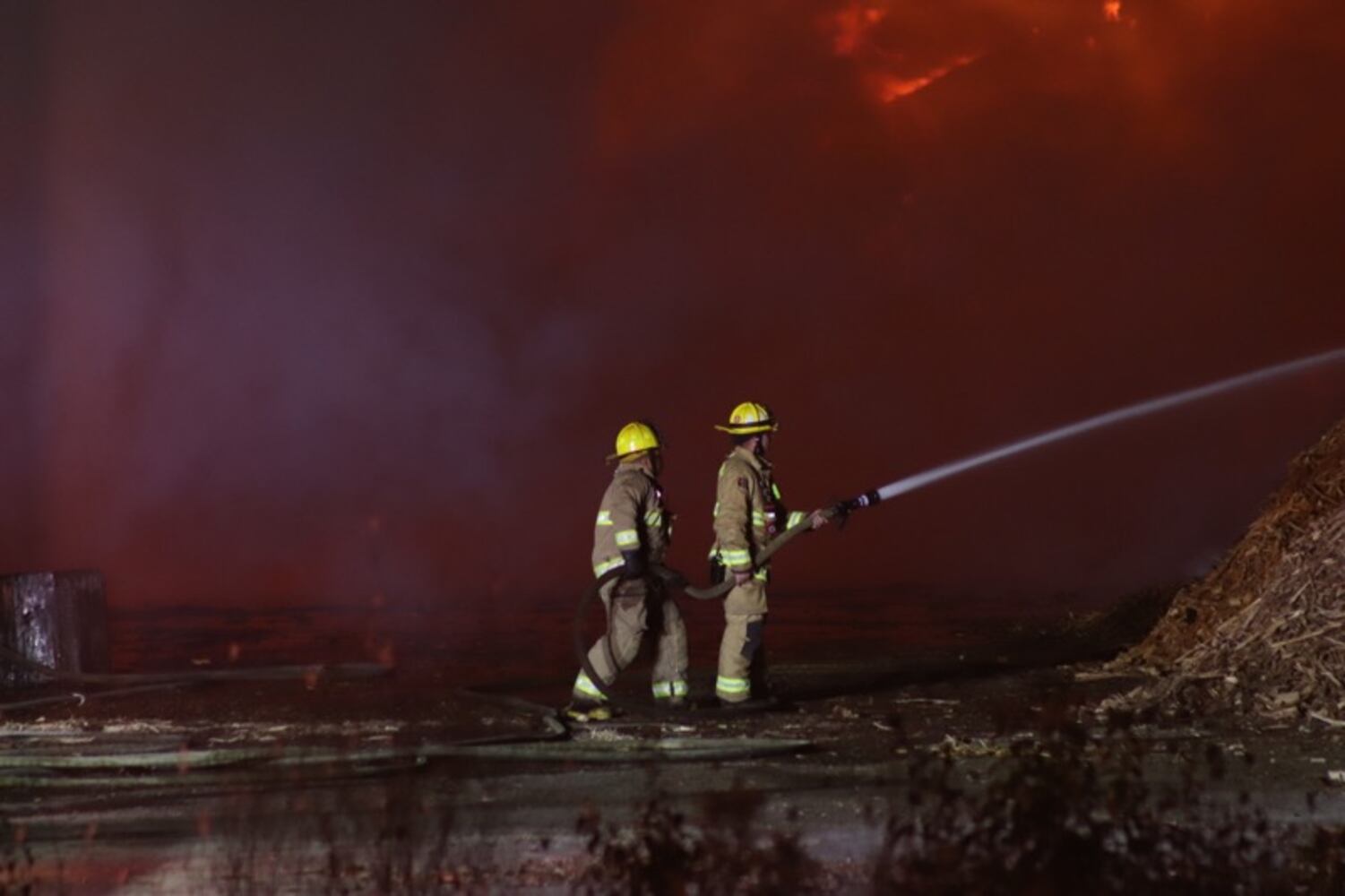 Fire crews battling huge fire in wood piles on Harshman Road
