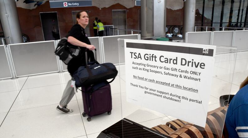 A traveler walks past a gift card donation box for Transportation Security Administration officers at Denver International Airport on Friday, March 20, 2026. (AP Photo/Thomas Peipert)