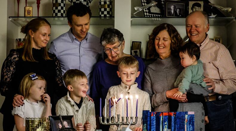 Four generations of the Bettman family light the menorah. From left, Janese Sweeny, Lily Sweeny, Dan Sweeny, Parker Sweeny Elaine Bettman, Leyton Sweeny, Melissa Sweeny, Sophie Sweeny and Tim Sweeny. JIM NOELKER/STAFF