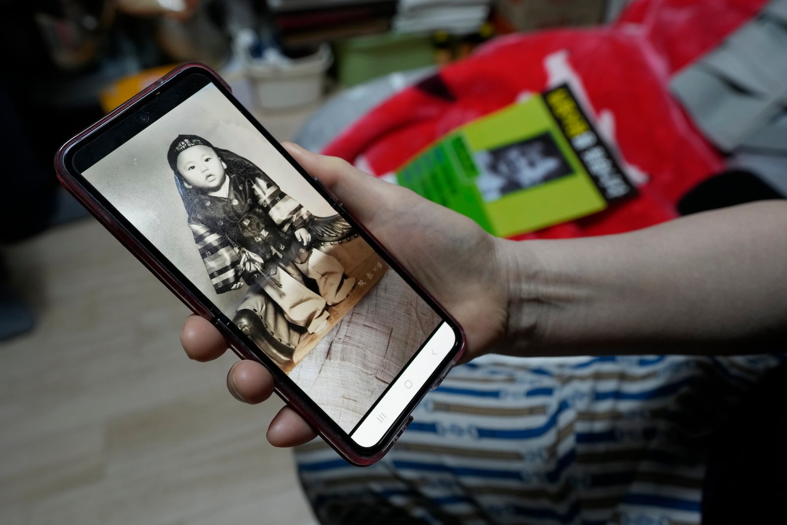 FILE - Choi Young-ja holds a smartphone displaying a photo of her son, who went missing in 1975, as she sits in her motel room in Seoul, South Korea, Tuesday, March 5, 2024. (AP Photo/Ahn Young-joon, File)
