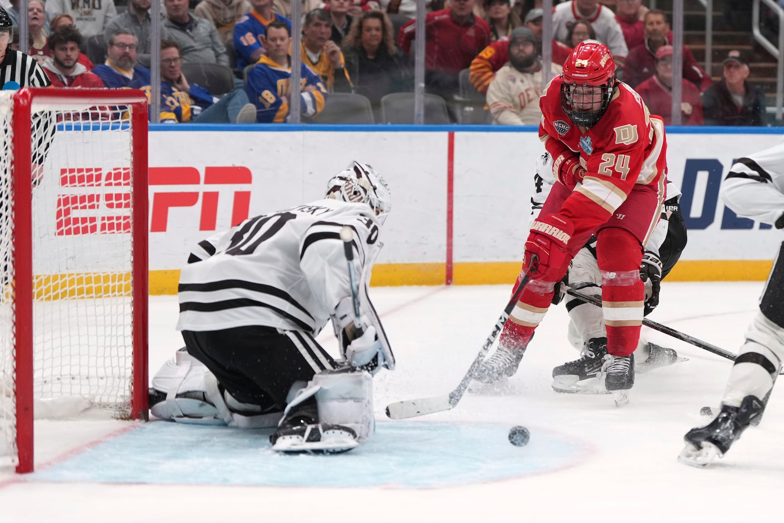 Denver's Kieran Cebrian (24) is unable to score past Western Michigan goaltender Hampton Slukynsky (30) during the first overtime in a semifinal game in the NCAA Frozen Four men's college hockey tournament, Thursday, April 10, 2025, in St. Louis (AP Photo/Jeff Roberson)