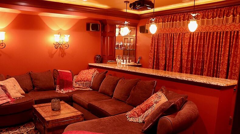 Off the family room, the custom built-in home theater has a stone bar with wine cooler nook and complete surround-sound system.