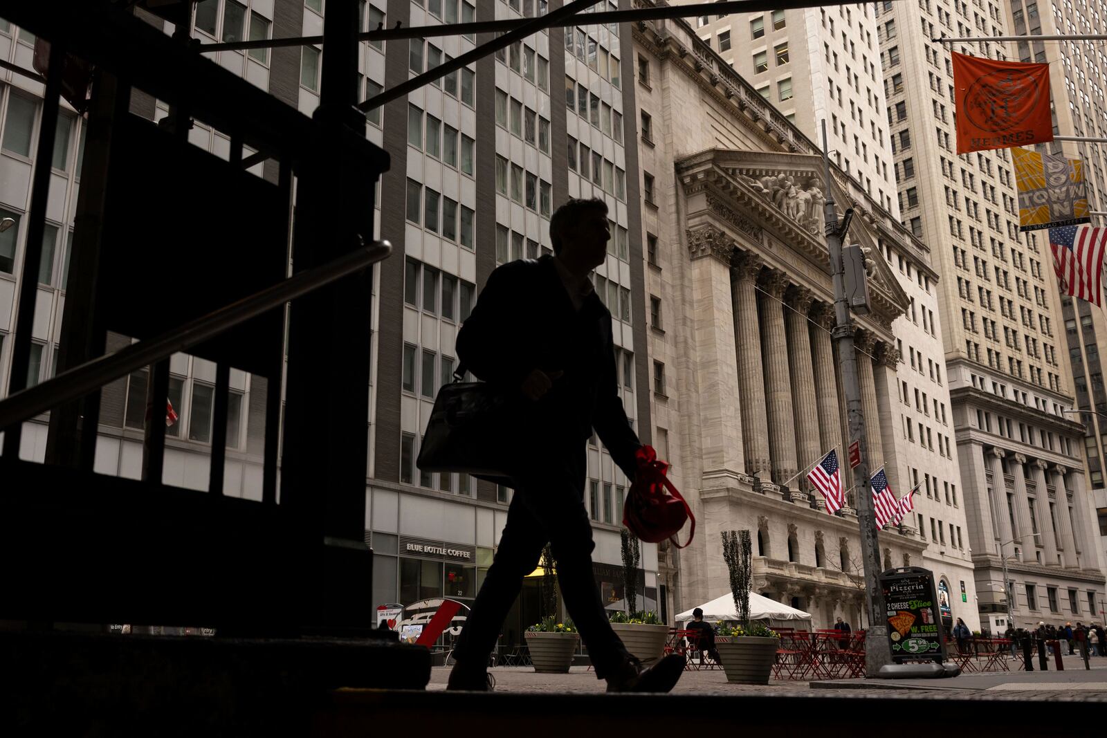People walk past the New York Stock Exchange, Thursday, April 10, 2025, in New York. (AP Photo/Yuki Iwamura)