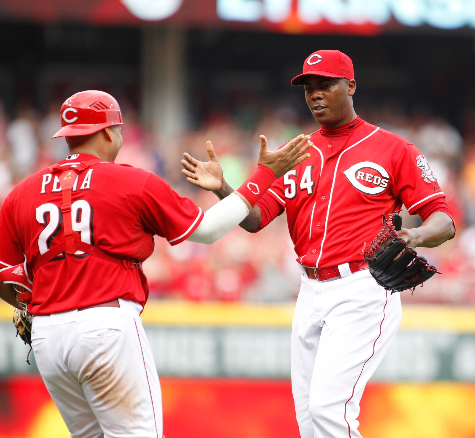 Reds catcher Brayan Pena, left, and closer Aroldis Chapman shake hands after beating the Nationals on Saturday, July 26, 2014, at Great American Ball Park in Cincinnati.