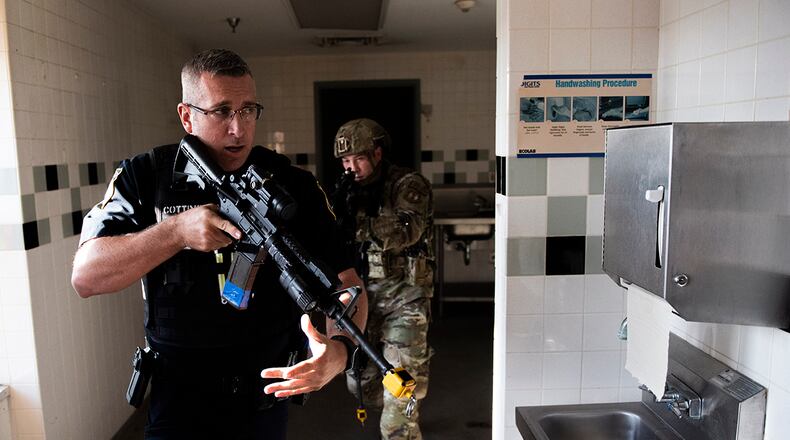 Members of the 88th Security Forces Squadron work to clear a building during an active-shooter exercise Aug. 18 at Wright-Patterson Air Force Base. Readiness exercises are routinely held to streamline unit cohesion when responding to emergencies. U.S. AIR FORCE PHOTO/WESLEY FARNSWORTH