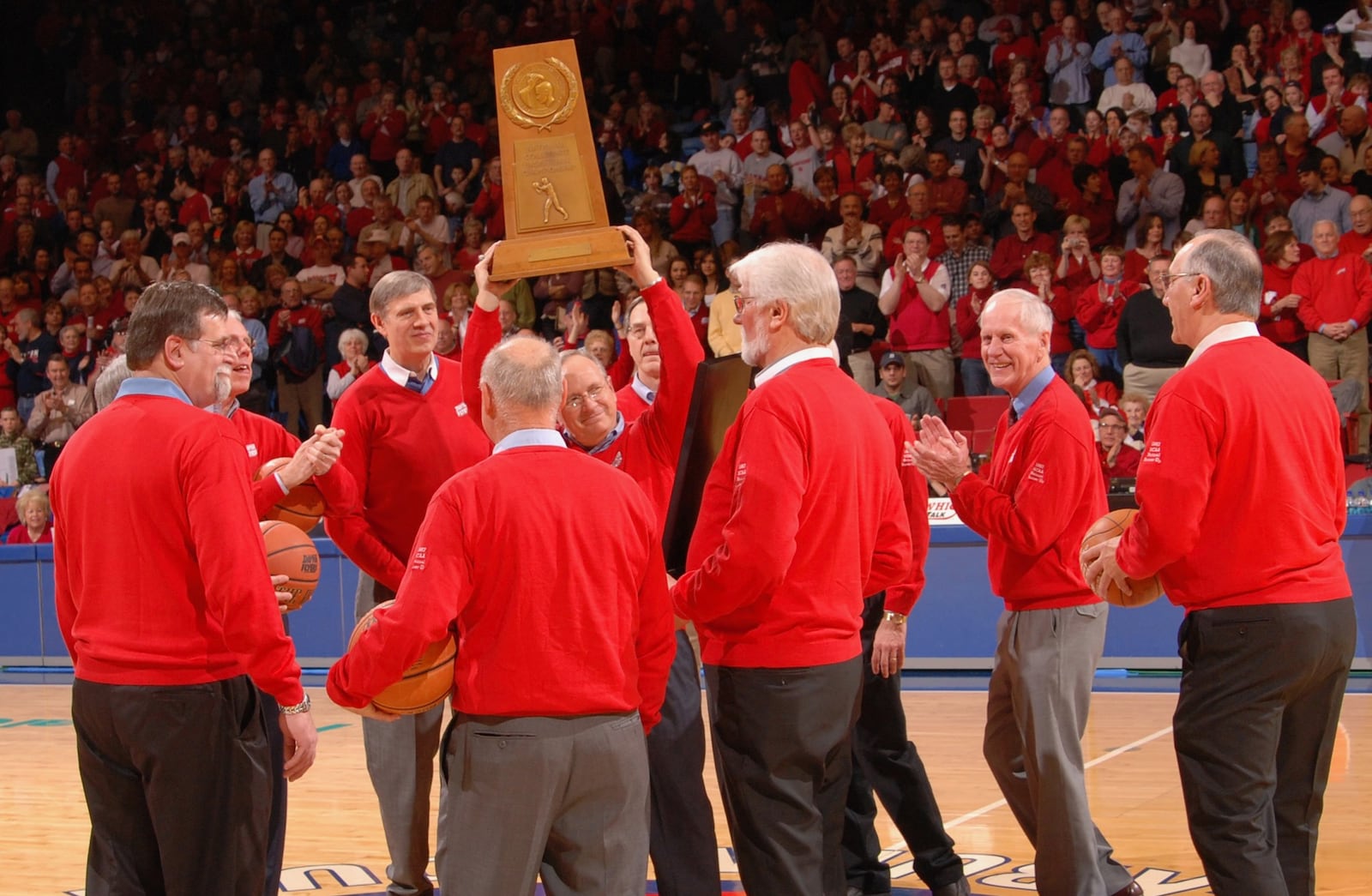 Bobby Joe Hooper, center, hoists the Dayton Flyers' 1967 NCAA runner-up trophy during a 40th reunion celebration at UD Arena in 2007. Photo by Timothy Boone