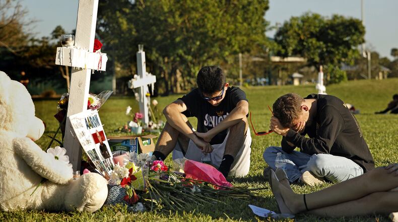 Students, friends and family gather at the memorial crosses at Pine Trails Park in Parkland, Fla., to remember those where were killed and injured in the shooting at Marjory Stoneman Douglas High School, on Friday, Feb. 16, 2018. (Carolyn Cole/Los Angeles Times/TNS)