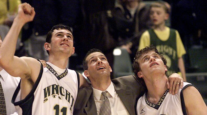 Wright State University’s head coach Ed Schilling puts his arms around his two senior players Cain Doliboa, left, and Jesse Deister, right, as they watch highlights from the season after winning their final season game against Loyola University at the Nutter Center on Sunday February 24, 2002.