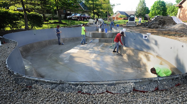A crew from Buckeye Pools works on installing a new pool Thursday, May 20, 2021. Pool businesses are still seeing high demand. MARSHALL GORBY\STAFF
