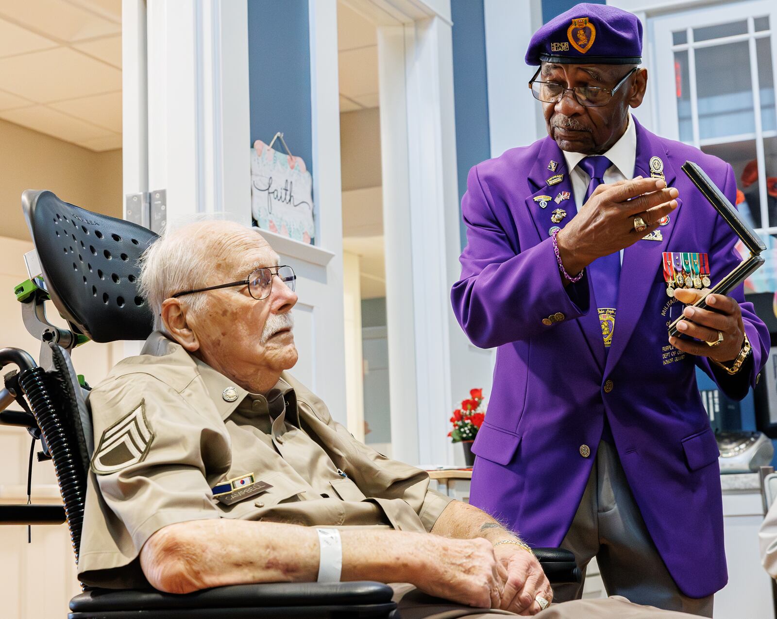 Jerry Ferris, the Ohio Commander of the Military Order of the Purple Heart, presents Korean War veteran Leroy Campbell with one of Ferris' purple heart medals during a program on Tuesday at Victory Ridge on the campus of Dayton VA Medical Center. Ferris received three purple hearts while serving during the Vietnam War. Work is in progress for Campbell to receive a Purple Heart, but Ferris decided to give Campbell one of his medals. BRYANT BILLING / STAFF