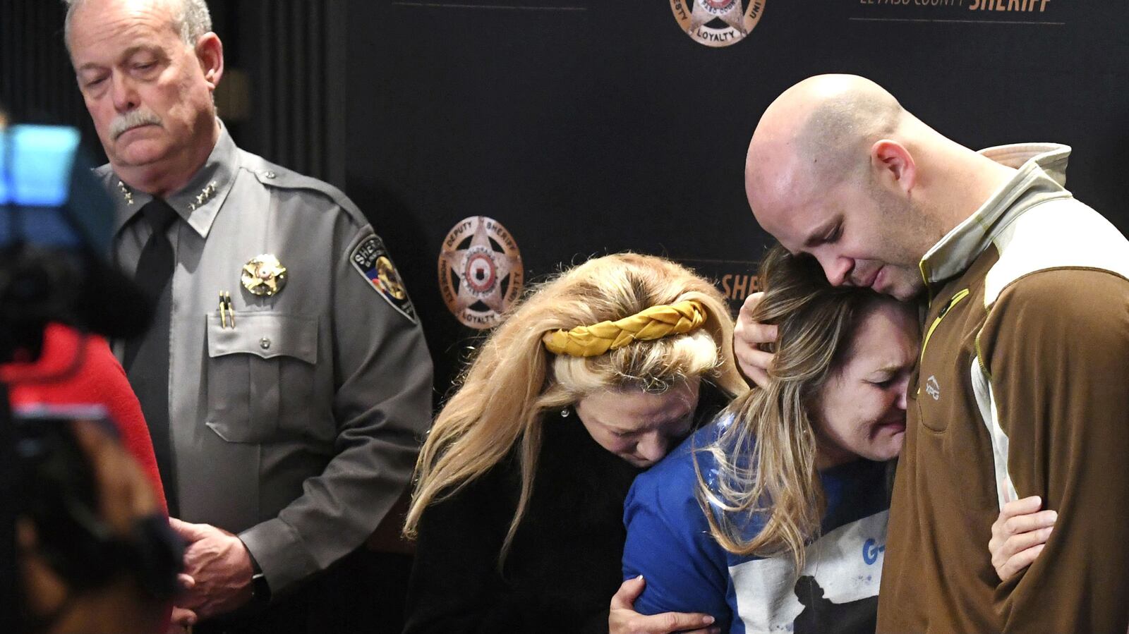 Al Stauch, far right, holds his ex-wife, Landen Hiott, Monday, March 2, 2020, during a news conference about the disappearance and killing of their son, 11-year-old Gannon Stauch, in Colorado Springs, Colo. Al Stauch's second wife, Letecia Stauch, has been charged with murder and related charges in the death of the boy, whose remains were found March 19 by a work crew in Pace, Fla.
