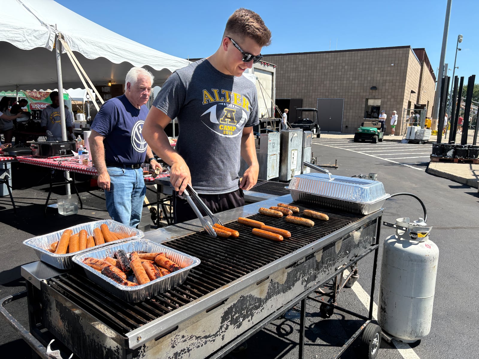 Alter High School alumnus and AlterFest volunteer Joe Manfre is grilling hotdogs, brats and burgers Saturday, Aug. 30, 2025, in Kettering. jEN BALDUF/STAFF