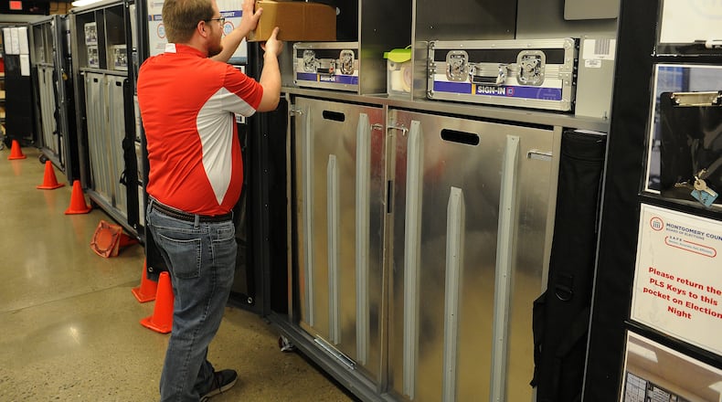 Cory Zimmerman, election services specialist at the Montgomery County Board of Elections, looks over machines as employees prepared for today's election. MARSHALL GORBY\STAFF