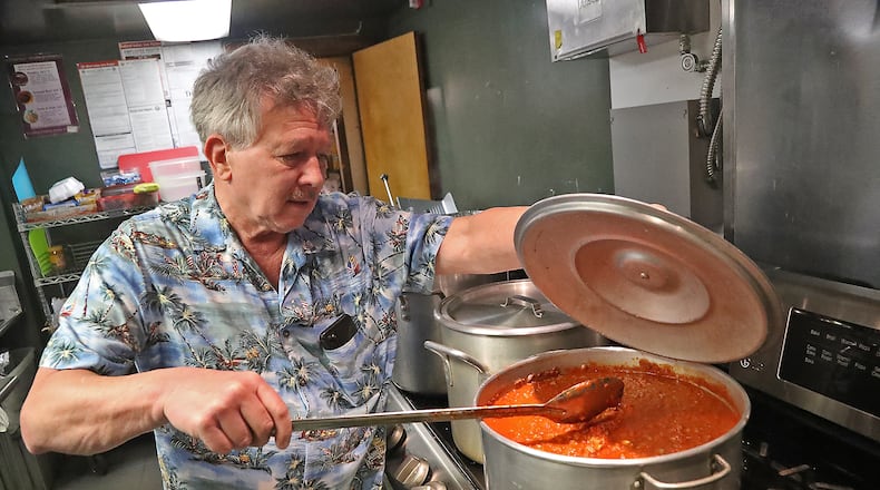 Fred Stegner, president of the Springfield Soup Kitchen, stirs the pasta sauce being served for dinner at the kitchen Monday night. BILL LACKEY/STAFF