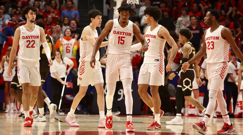 Dayton players head to a huddle during a timeout against Western Michigan on Wednesday, Nov. 30, 2022, at UD Arena. David Jablonski/Staff