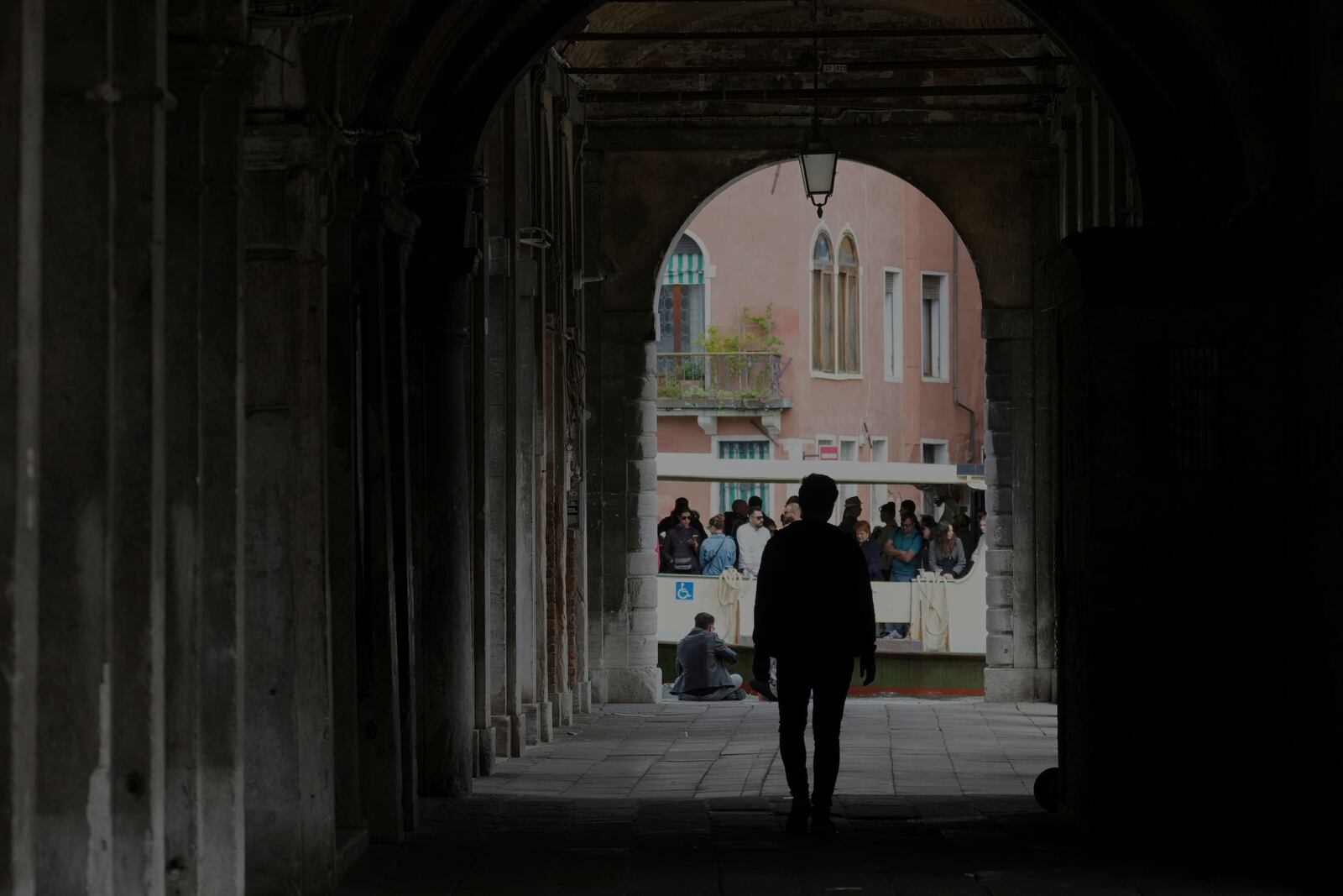 A man walks as people stand on a water bus "Vaporetto" in Venice Italy, Friday, April 18, 2025, Venice on Friday launches for a second year a pilot program to charge day-trippers an entrance fee. (AP Photo/Antonio Calanni)