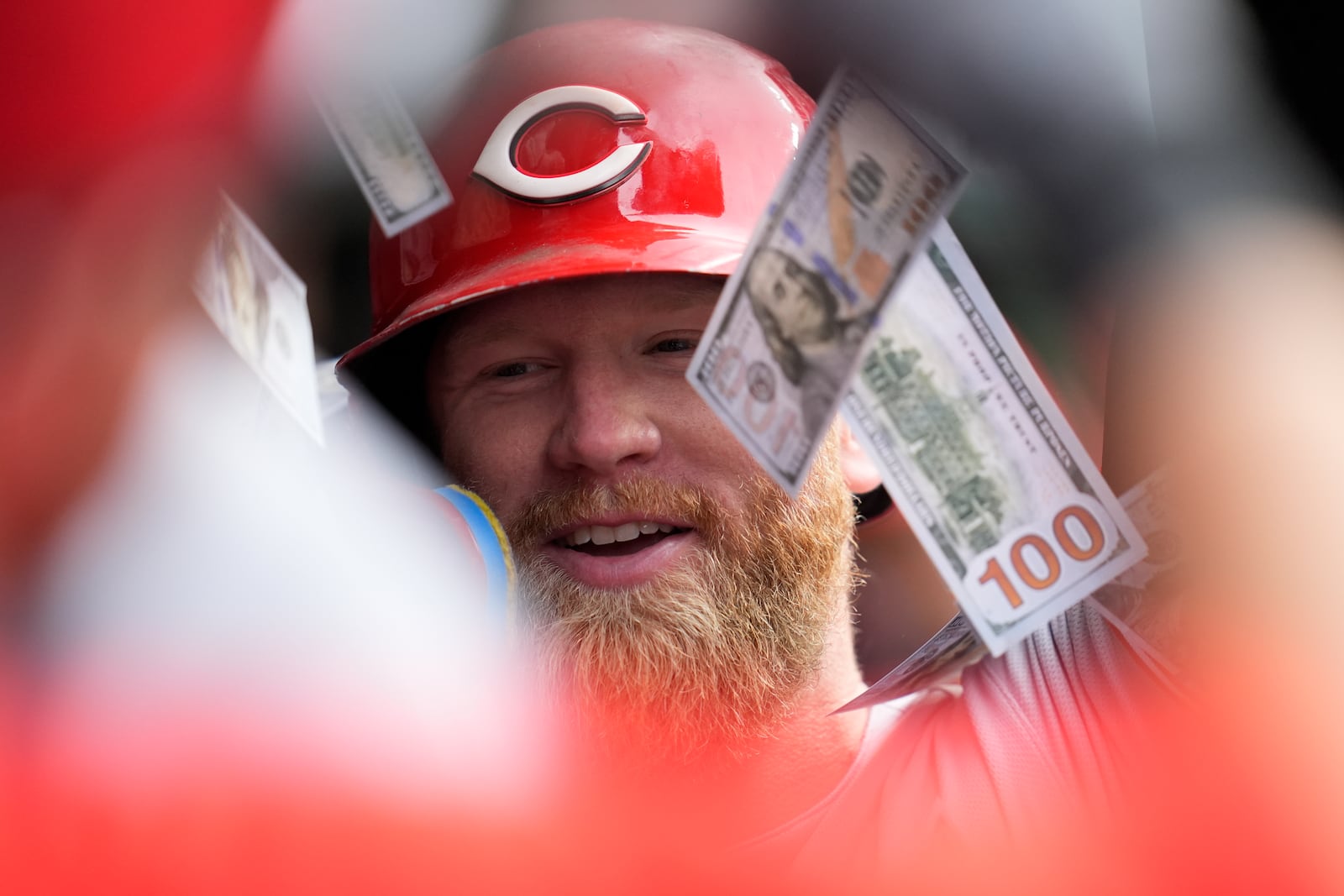 Cincinnati Reds right fielder Jake Fraley (27) is showered in fake money from his teammates in the dugout after hitting a two-run home run during the fifth inning of a baseball game against the Chicago Cubs, Friday, May 30, 2025, in Chicago. (AP Photo/Erin Hooley)