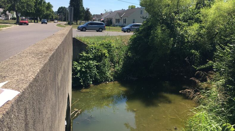 The seemingly innocuous Two Mile Creek in Hamilton will cost some property owners flood insurance because federal authorities have expanded the flood map in Hamilton to include several dozen properties that previously were not included in the estimated flood risk area. MIKE RUTLEDGE/STAFF