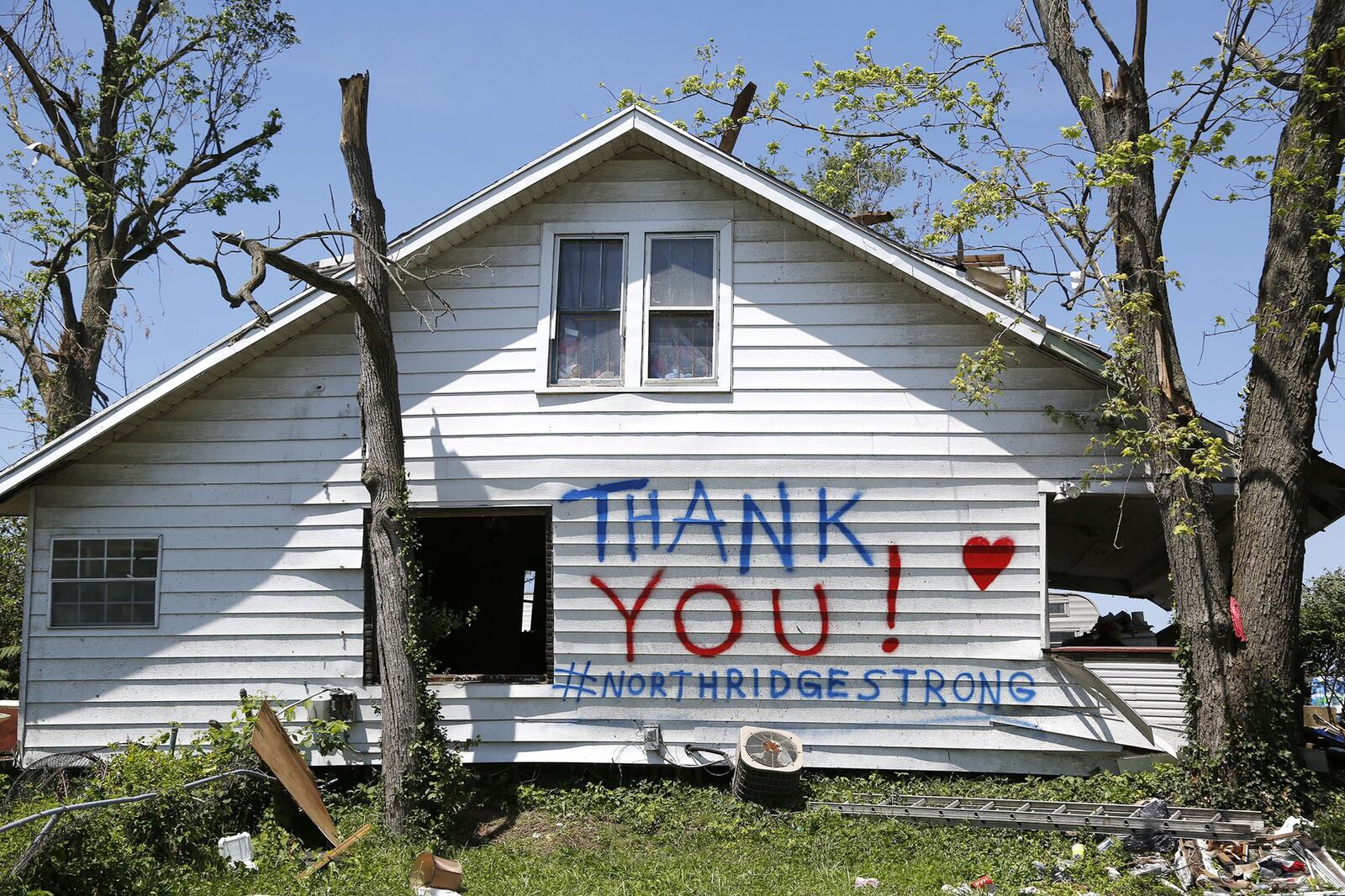 A damaged house on Maplegrove Avenue in Northridge with a message to neighbors after the Memorial Day tornadoes. TY GREENLEES / STAFF