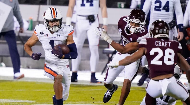 Auburn wide receiver Anthony Schwartz (1) runs with a reception past Mississippi State defenders for a first down during the first half of an NCAA college football game Saturday, Dec. 12, 2020, in Starkville, Miss. (AP Photo/Rogelio V. Solis)