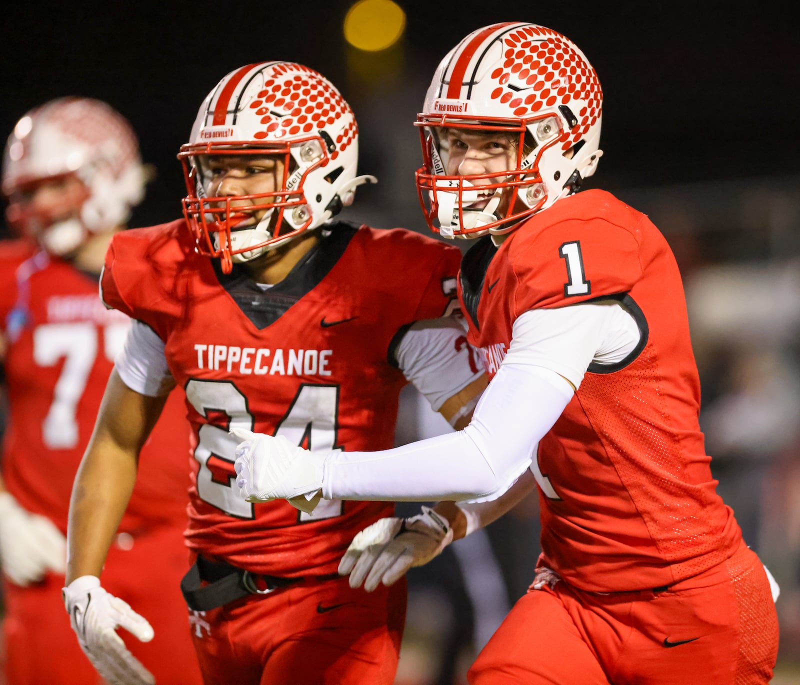 Tippecanoe senior receiver Will Strong congratulates Xavier Melton after Melton scored a 52-yard touchdown run during the first quarter of a Division III, Region 12 quarterfinal on Friday, Nov. 7 at Tipp City Park. The Red Devils won 55-7. BRYANT BILLING/STAFF