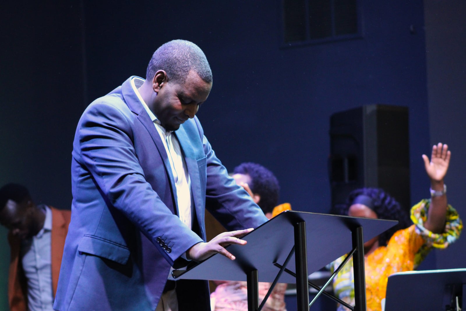 Pastor Desire Ntwayingabo bows his head in prayer during a service at Penuel Church of the Nazarene in Huber Heights on Sunday, July 20. STAFF/SYDNEY DAWES