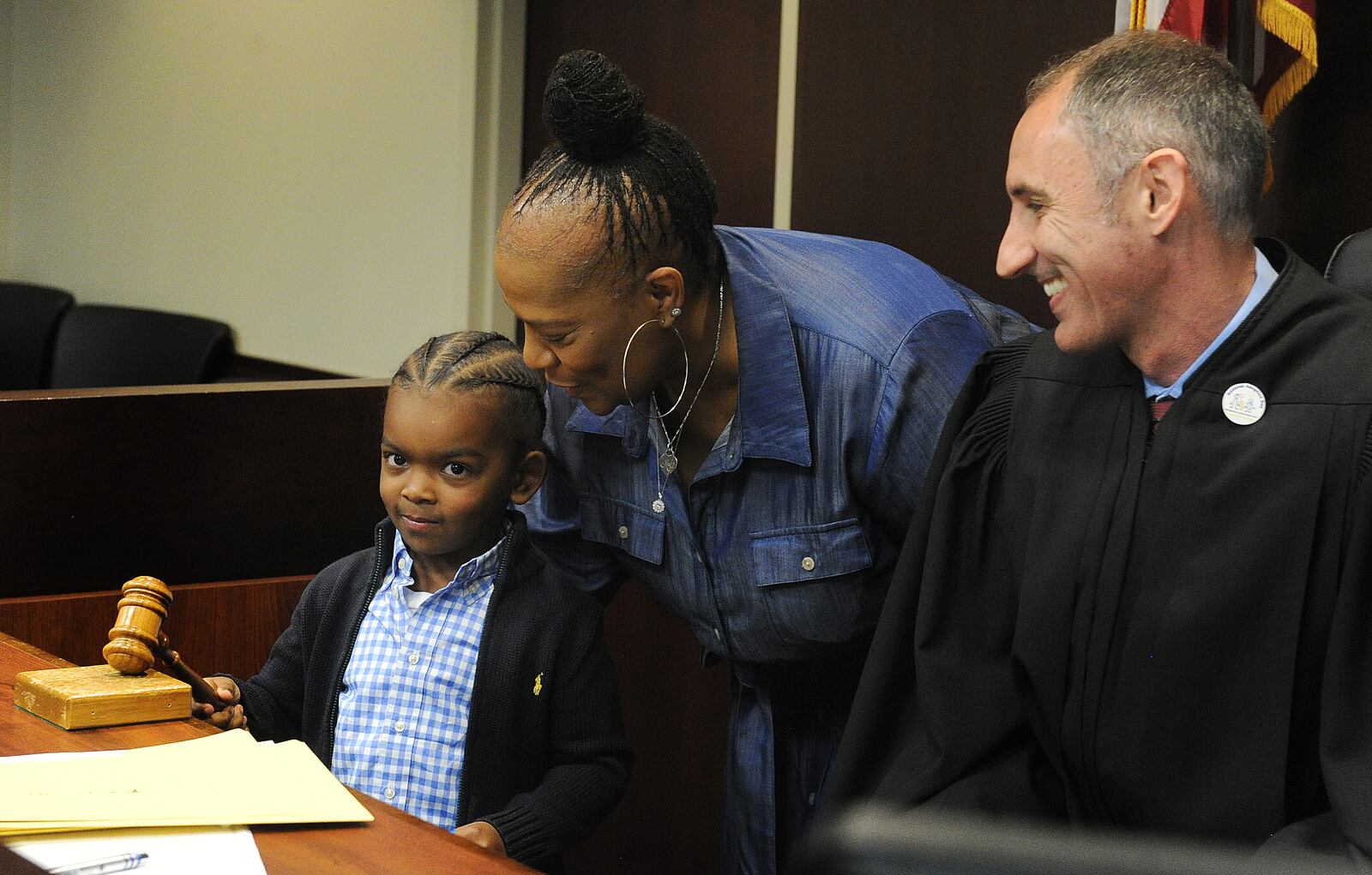 Jayce and Crystal Cook bang the gavel -- a tradition at adoption ceremonies in Montgomery County -- as Montgomery County Probate Court Judge David Brannon smiles at the family. MARSHALL GORBY\STAFF