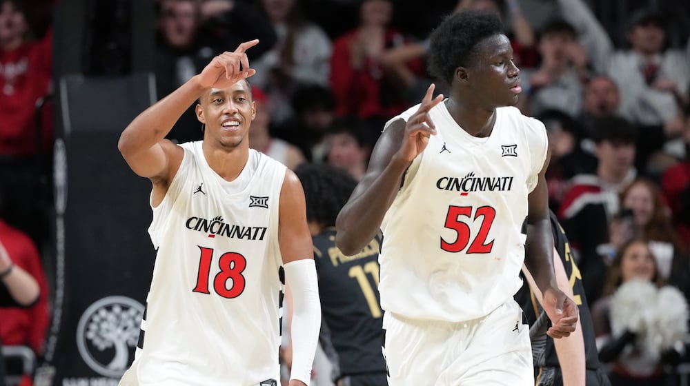 Cincinnati's Baba Miller, left, smiles after dunking during the second half of an NCAA college basketball game against Central Florida, Sunday, Feb. 8, 2026, in Cincinnati. (AP Photo/Kareem Elgazzar)