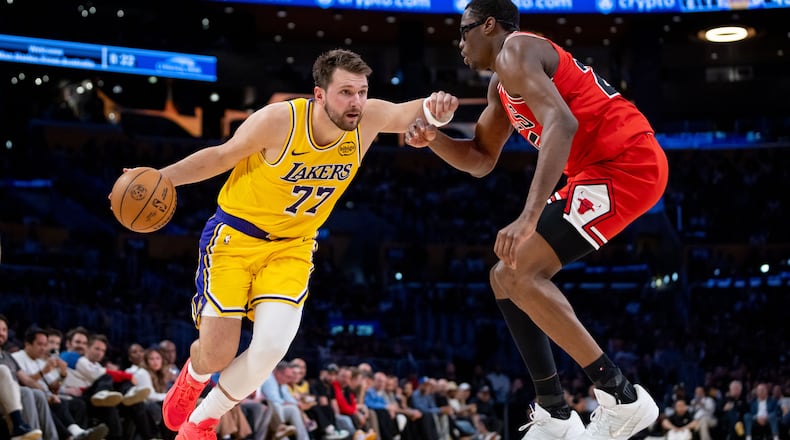 Los Angeles Lakers guard Luka Doncic (77) is defended by Chicago Bulls forward Jalen Smith, right, during the first half of an NBA basketball game against the Chicago Bulls, Thursday, March 12, 2026, in Los Angeles. (AP Photo/Ethan Swope)