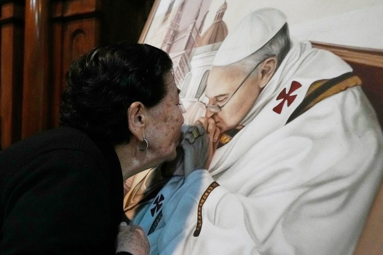 A parishioner kisses a painting of the late Pope Francis at the Basílica de San José de Flores, where he worshipped as a youth, following the Vatican's announcement of his death in Buenos Aires, Argentina, Monday, April 21, 2025. (AP Photo/Gustavo Garello)