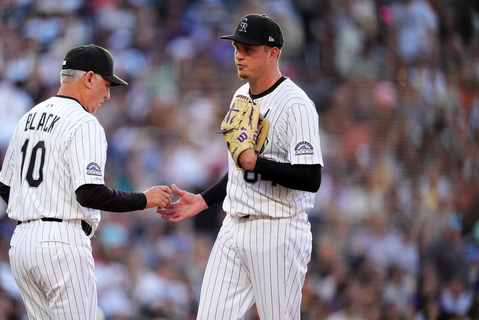 Colorado Rockies manager Bud Black, left, takes the ball from starting pitcher Bradley Blalock, right, who is pulled from the mound after giving up a two-run home run to San Diego Padres' Jason Heyward in the fourth inning of a baseball game Saturday, May 10, 2025, in Denver. (AP Photo/David Zalubowski)