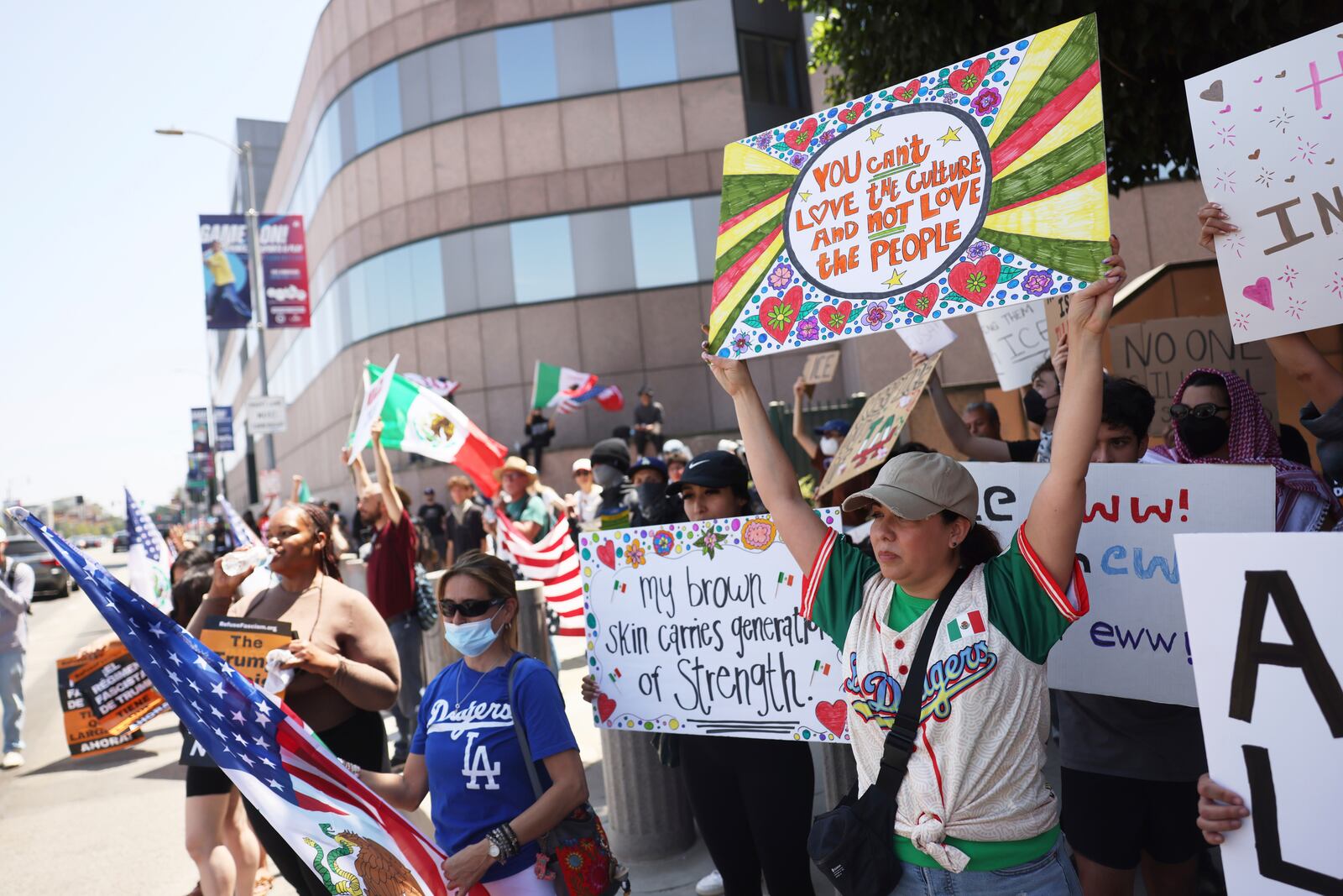 Demonstrators hold signs during a protest, Thursday, June 12, 2025, in Los Angeles. (AP Photo/Etienne Laurent)