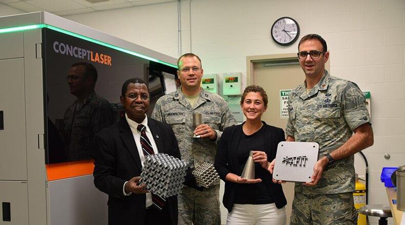 Dr. Adedeji Badiru, Capt. Andrew Lingenfelter, Jessica Smith and Maj. Ryan O’Hara stand with samples made from Air Force Institute of Technology’s state-of-the-art metal additive manufacturing system. (U.S. Air Force photo/Katie Scott)