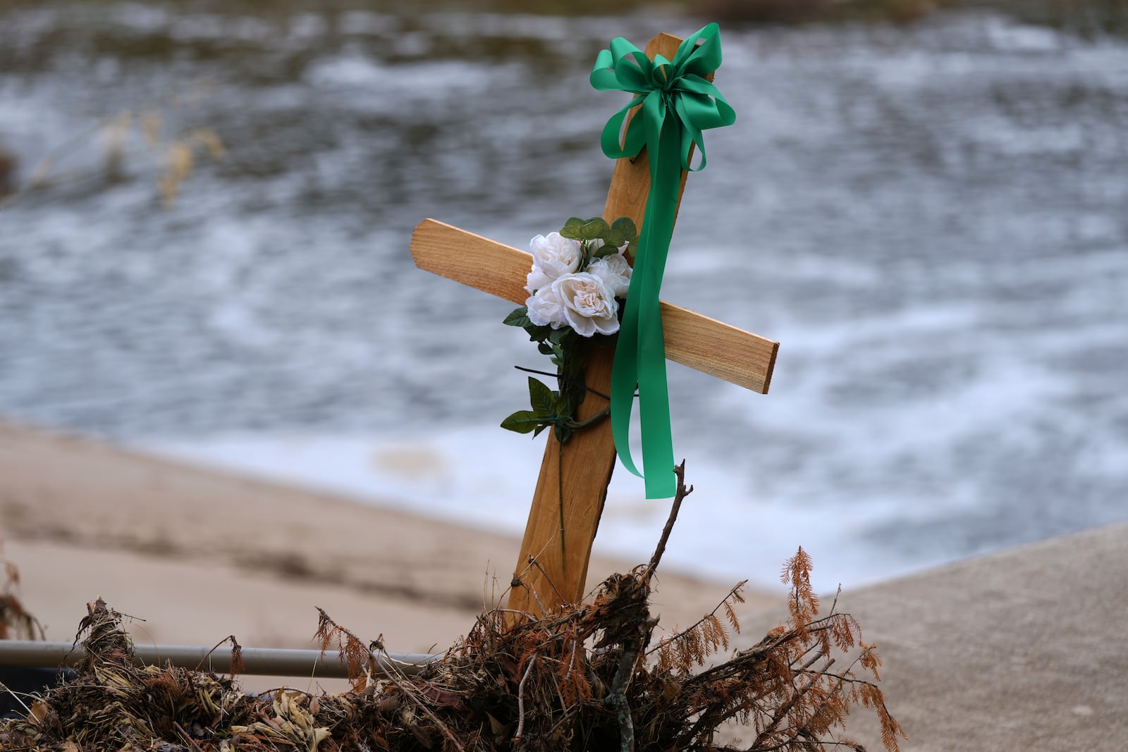 A cross stands in debris at a make-shift memorial honoring flood victims, Sunday, July 13, 2025, in Kerrville, Texas. (AP Photo/Eric Gay)