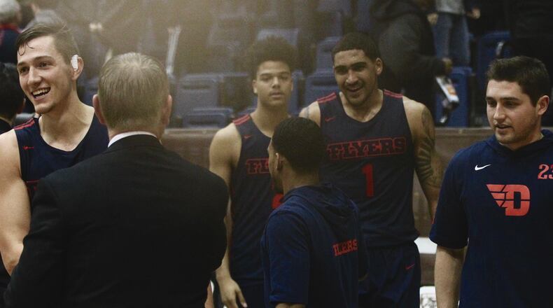 Dayton’s Ryan Mikesell, left, smiles as he leaves the court after a victory against St. Bonaventure on Saturday, Jan. 19, 2019, at the Reilly Center in Olean, N.Y. David Jablonski/Staff