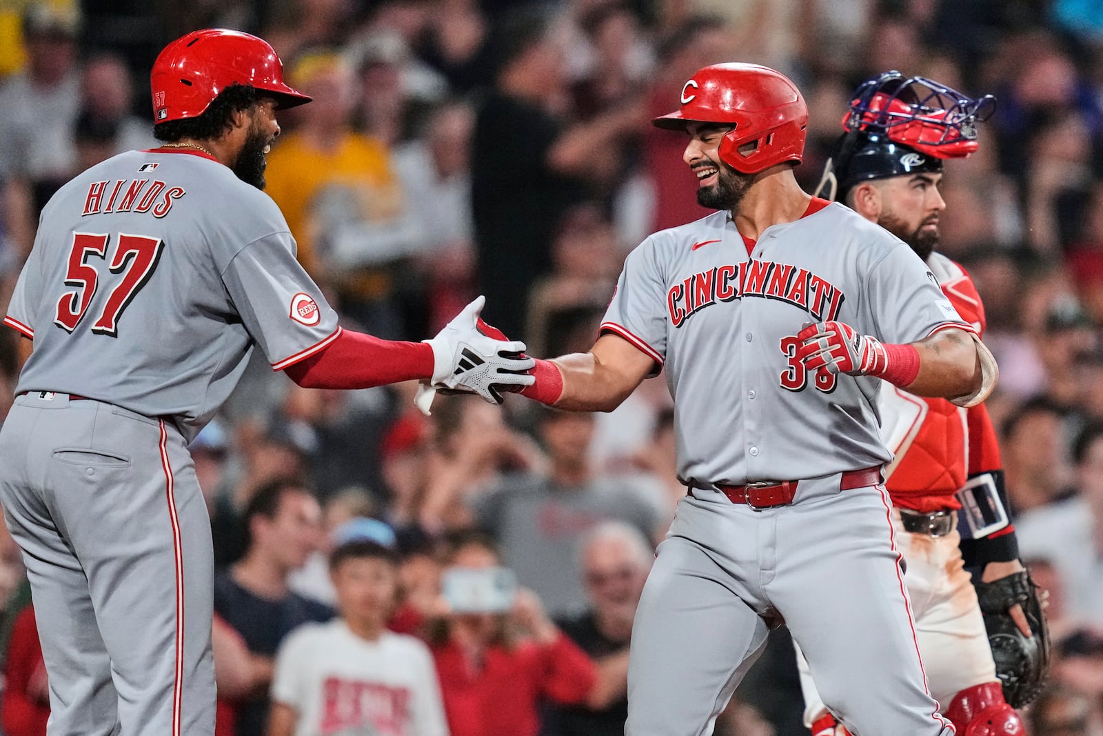 Cincinnati Reds' Christian Encarnacion-Strand, right, is congratulated by Rece Hinds (57) after his grand slam drive against the Boston Red Sox during the seventh inning of a baseball game at Fenway Park, Wednesday, July 2, 2025, in Boston. (AP Photo/Charles Krupa)