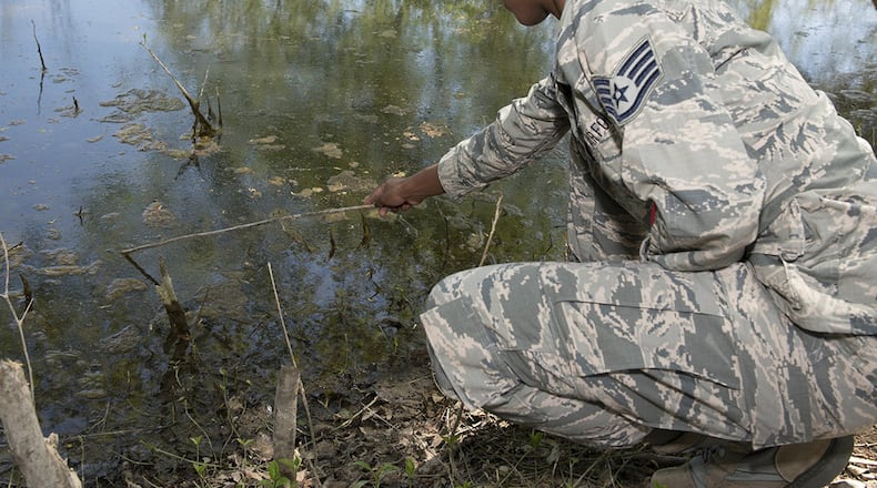 Staff Sgt. Brittany Wiggins, U.S. Air Force School of Aerospace Medicine public health instructor, skims the surface of Twin Lakes, Wright-Patterson Air Force Base, May 8 to look for mosquito larvae. When mosquito larvae is bothered or disturbed, the movement of larvae helps Wiggins capture the mosquito larvae for testing. (U.S. Air Force photo/Michelle Gigante)