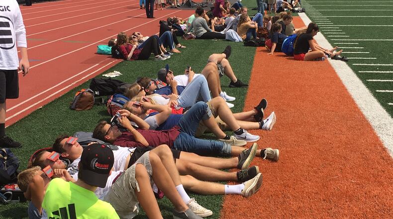 Students from Waynesville schools watch Monday’s solar eclipse on the high school’s football field. JEREMY P. KELLEY / STAFF