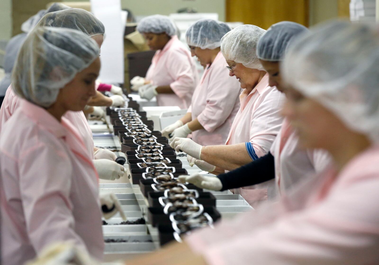 Esther Price Candies workers pack boxes of mixed chocolates.  TY GREENLEES / STAFF