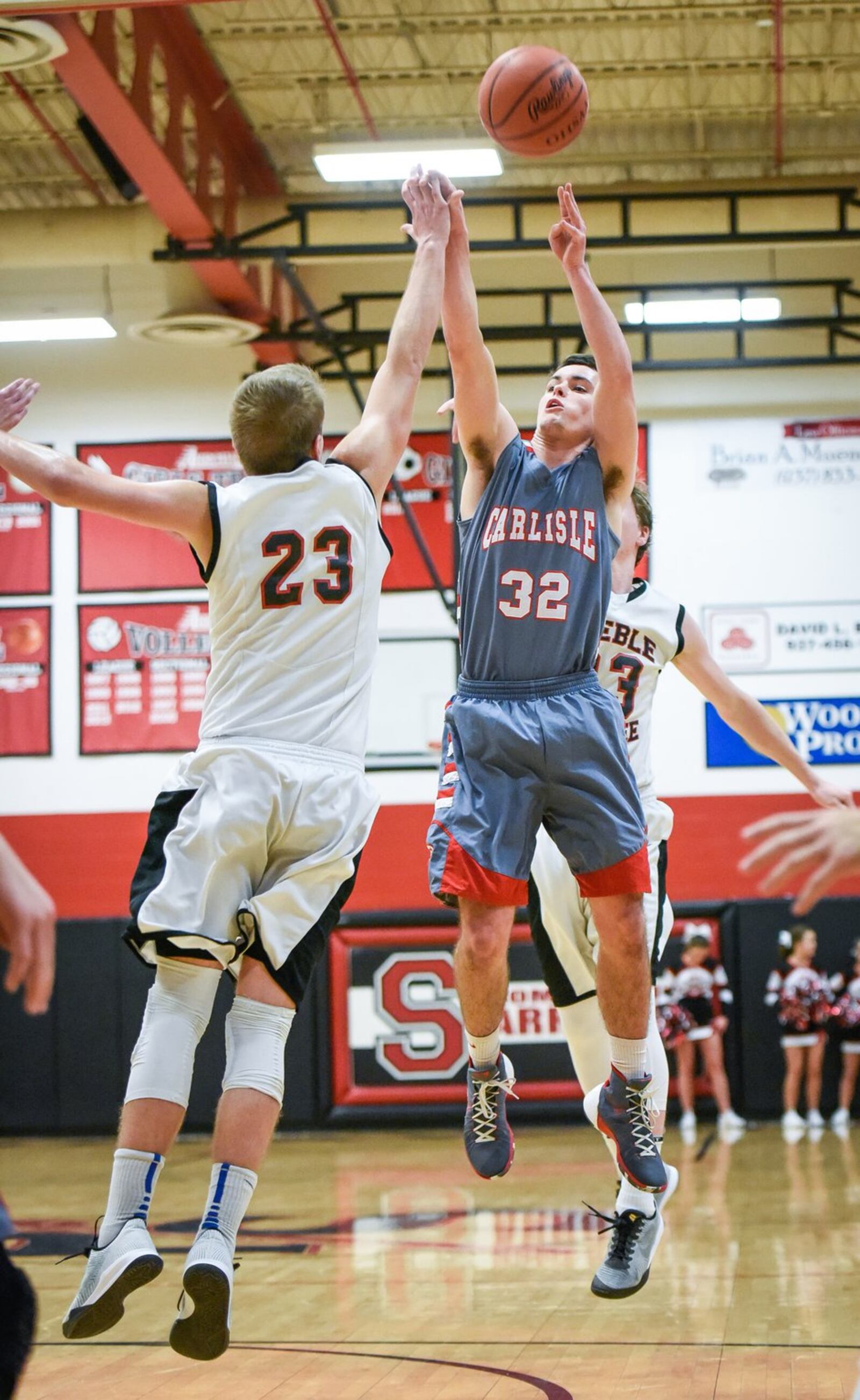 Carlisle’s Adam Goodpaster puts up a shot over Preble Shawnee’s Joey Bates during their game Friday night at Shawnee. NICK GRAHAM/STAFF