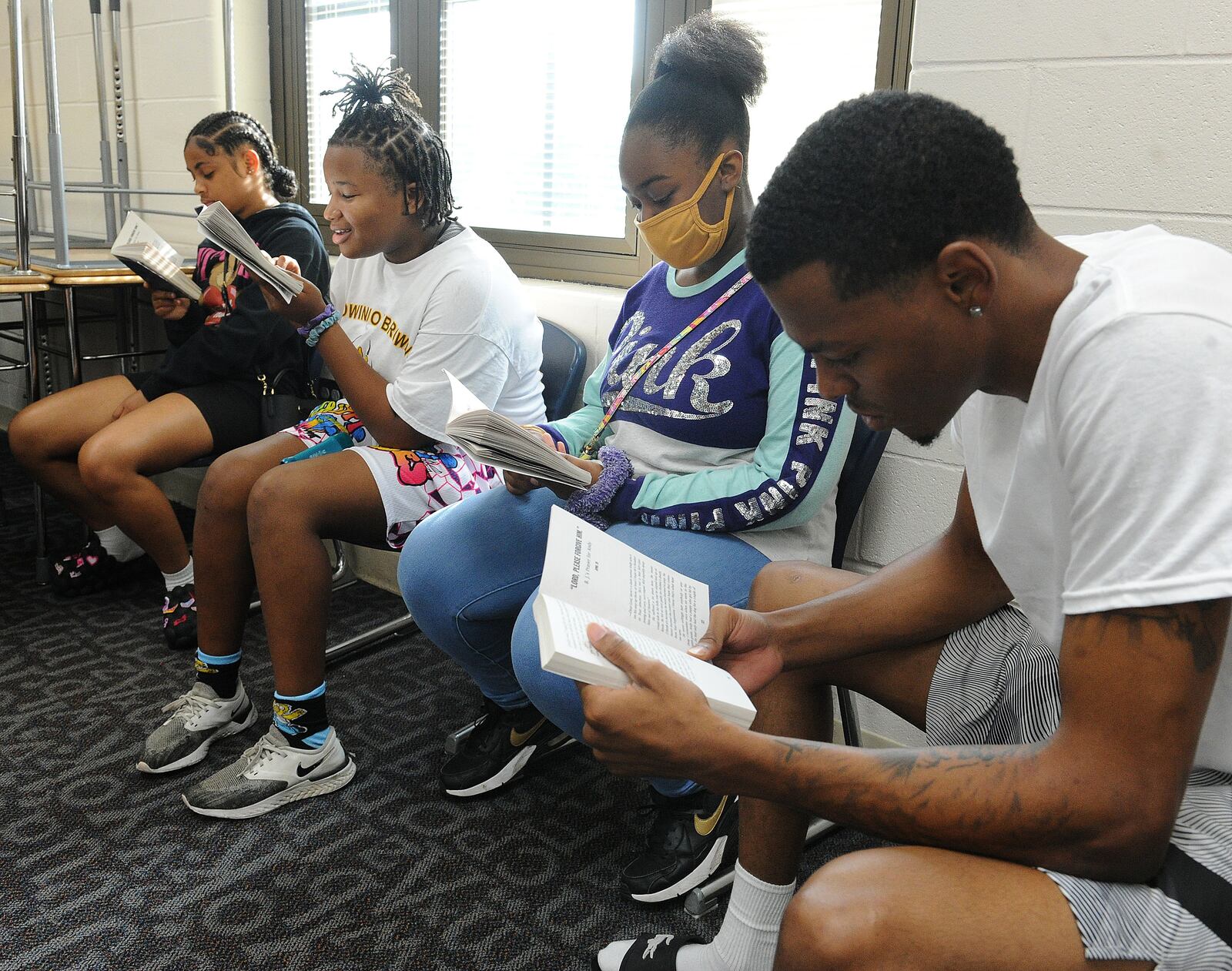 Students, from left, Jordan Jamerson, LaVonna Whatley and Shayla Davis, read with Servant Leader Intern, Terry Matthews III, during a DPS Summer Camp at Edwin Joel Brown Middle School. MARSHALL GORBY\STAFF