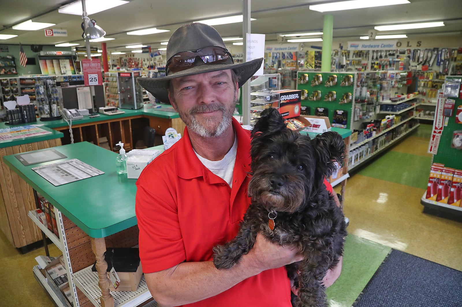 Brant Cornelison, owner of the Brain Lumber Company on East Street in Springfield, with "Charlie" in the hardware section of the business Wednesday, Oct. 26, 2022. Brant started working at the 157-year-old business when he was 14 years old. BILL LACKEY/STAFF