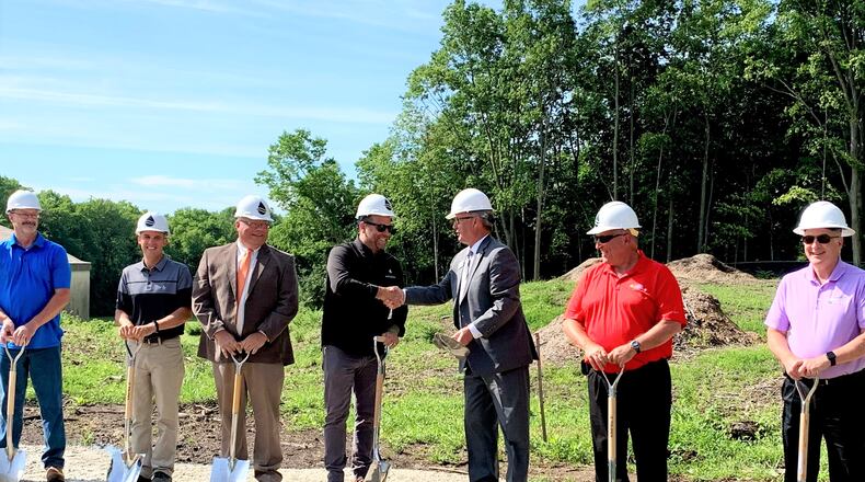 Greene County Sanitary Engineering Director Jason Tincu (center left) shakes hands with County Commissioner Tom Koogler as the county breaks ground on a water treatment plant upgrade that will add 3 million gallons to its capacity. LONDON BISHOP/STAFF