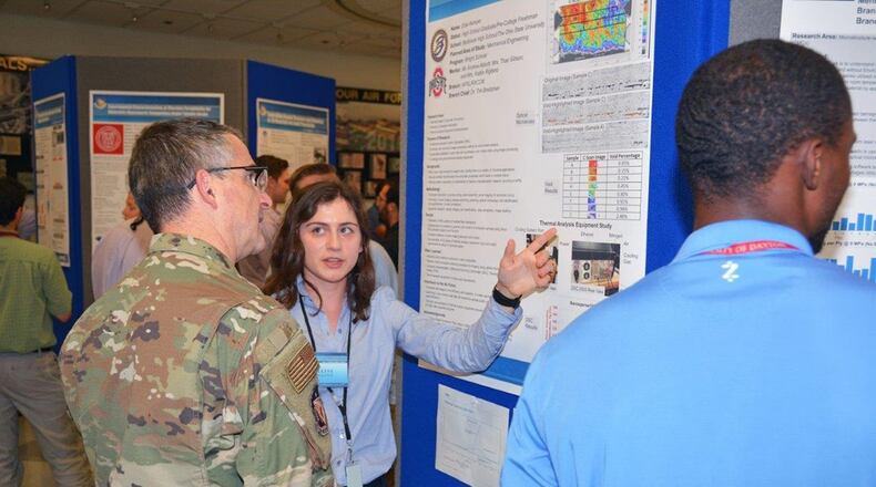 Elise Kemper, a 2019 Belbrook High School graduate, presents her research poster to Maj. Gen. William T. Cooley, commander of the Air Force Research Laboratory, at the summer student research poster session Aug. 1. Kemper’s research area this summer was polymeric matrix composites. She will be attending Ohio State University this fall, studying mechanical engineering. (U.S. Air Force photo/Spencer Deer)